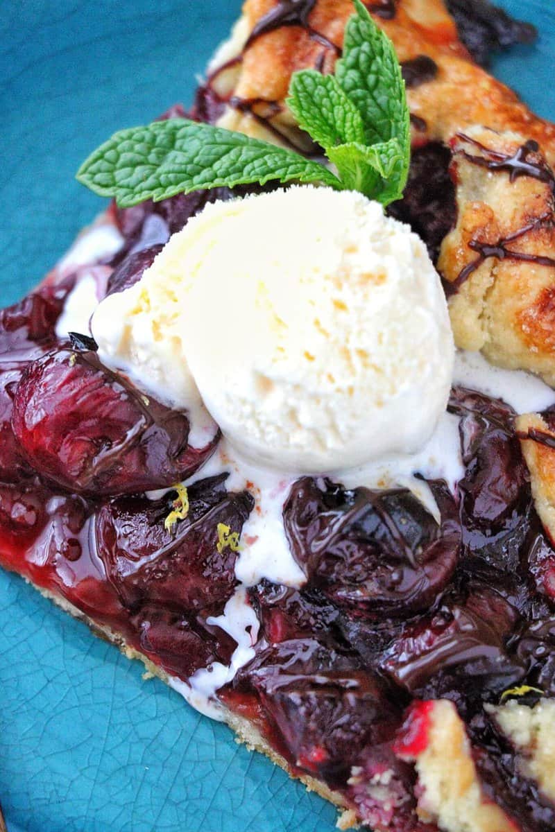 Cherry Galette with Chocolate Port Sauce and ice cream on a plate.
