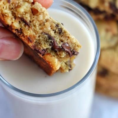 Chocolate Chip Walnut Cookies being dipped in milk