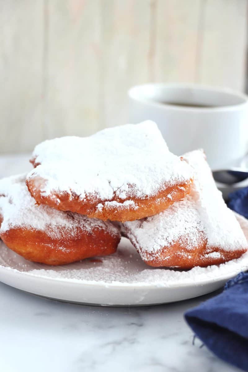 Classic Beignets on a plate and cup of coffee