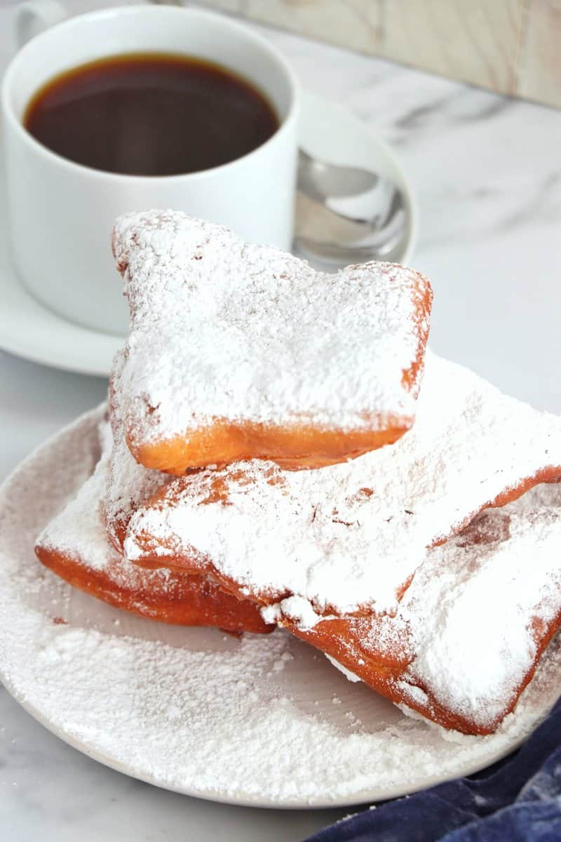 Overhead view of Classic Beignets on a plate and cup of coffee 