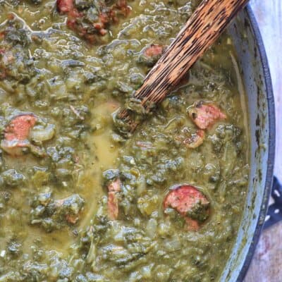 Close up overhead view of Gumbo Z'herbes in and pot with a wooden spoon