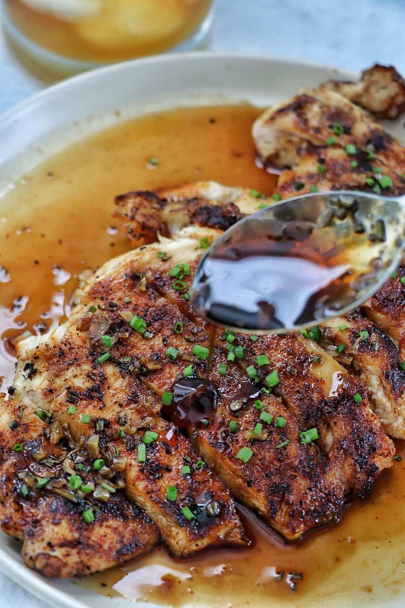 Sauce pouring over grilled chicken