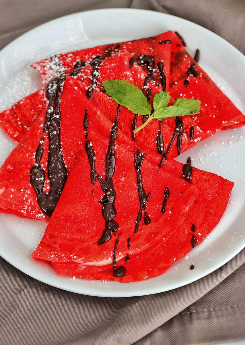 Red Velvet Crepe drizzled with chocolate syrup.