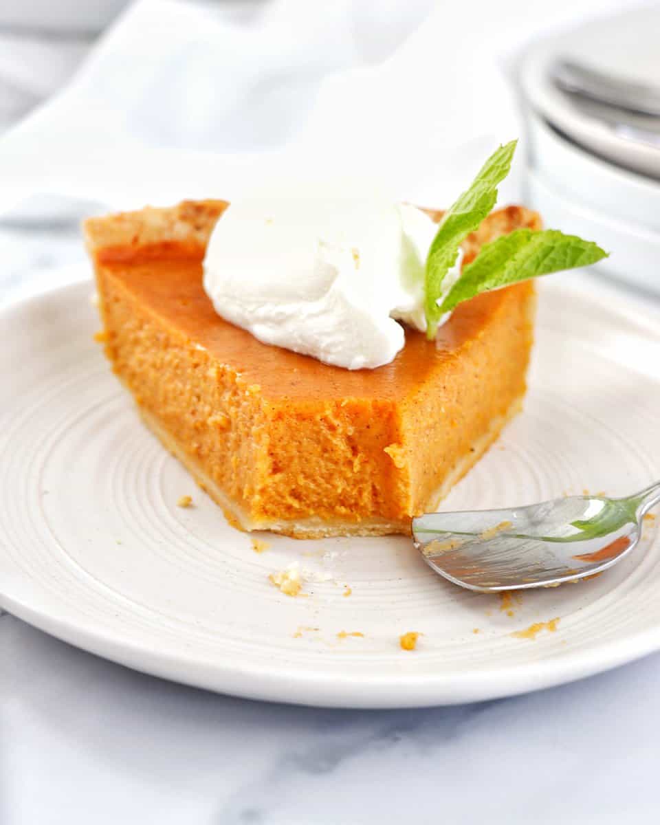 Slice of Sweet Potato Pie on a plate missing a bite