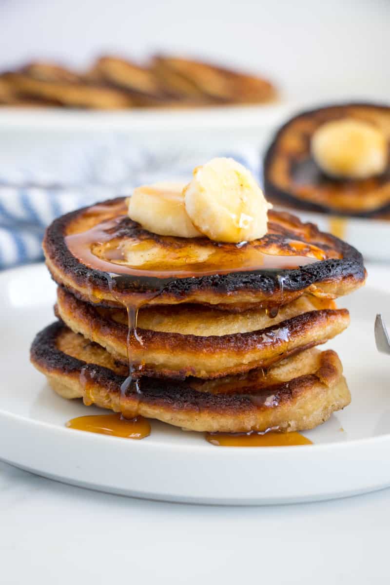 syrup dripping from a stack of banana pancakes