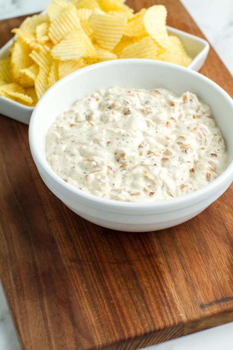 Caramelized French Onion Dip on a wooden cutting board