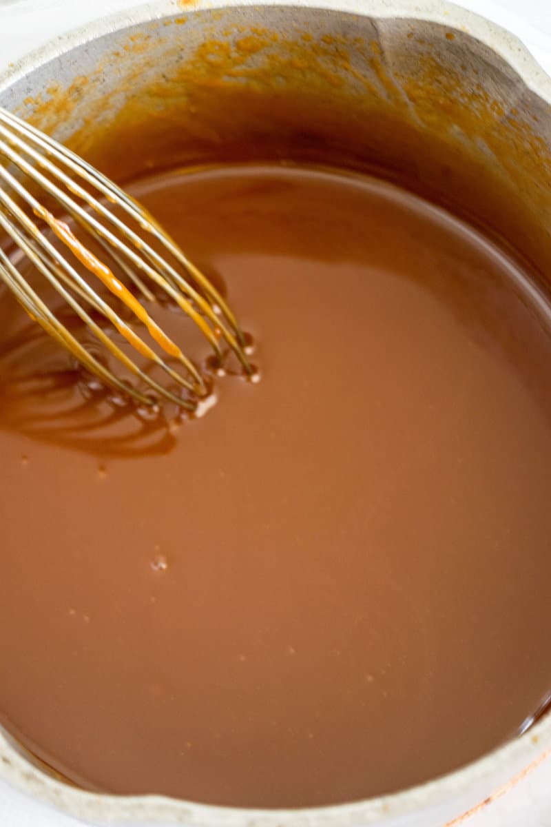 caramel sauce in pot with whisk