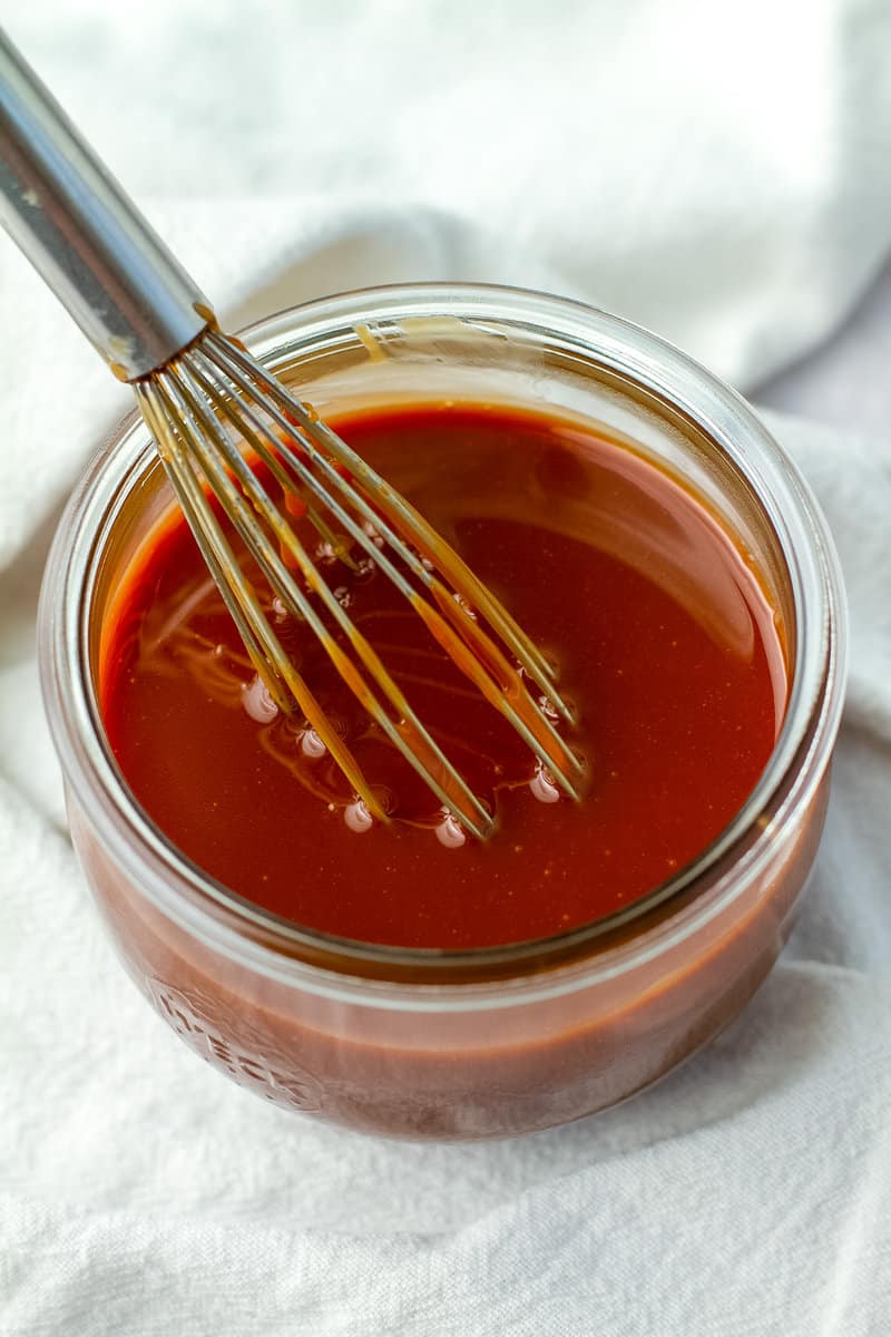 caramel sauce in glass jar with whisk