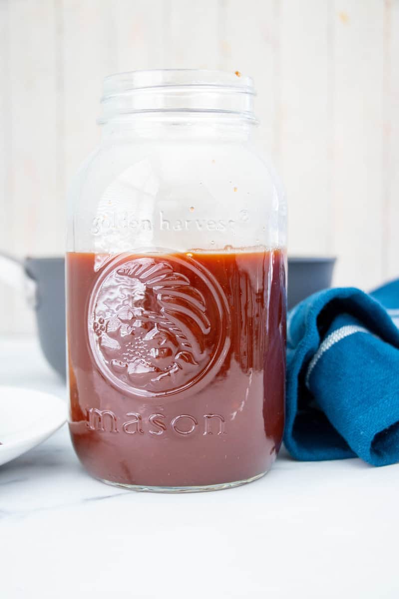 Honey bbq sauce in mason jar with blue towel