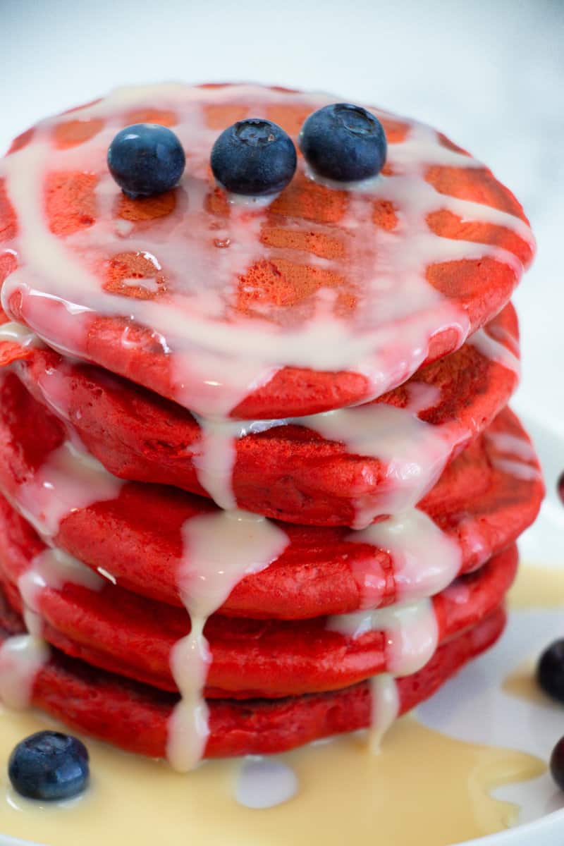 Stack of red velvet pancakes with condensed milk