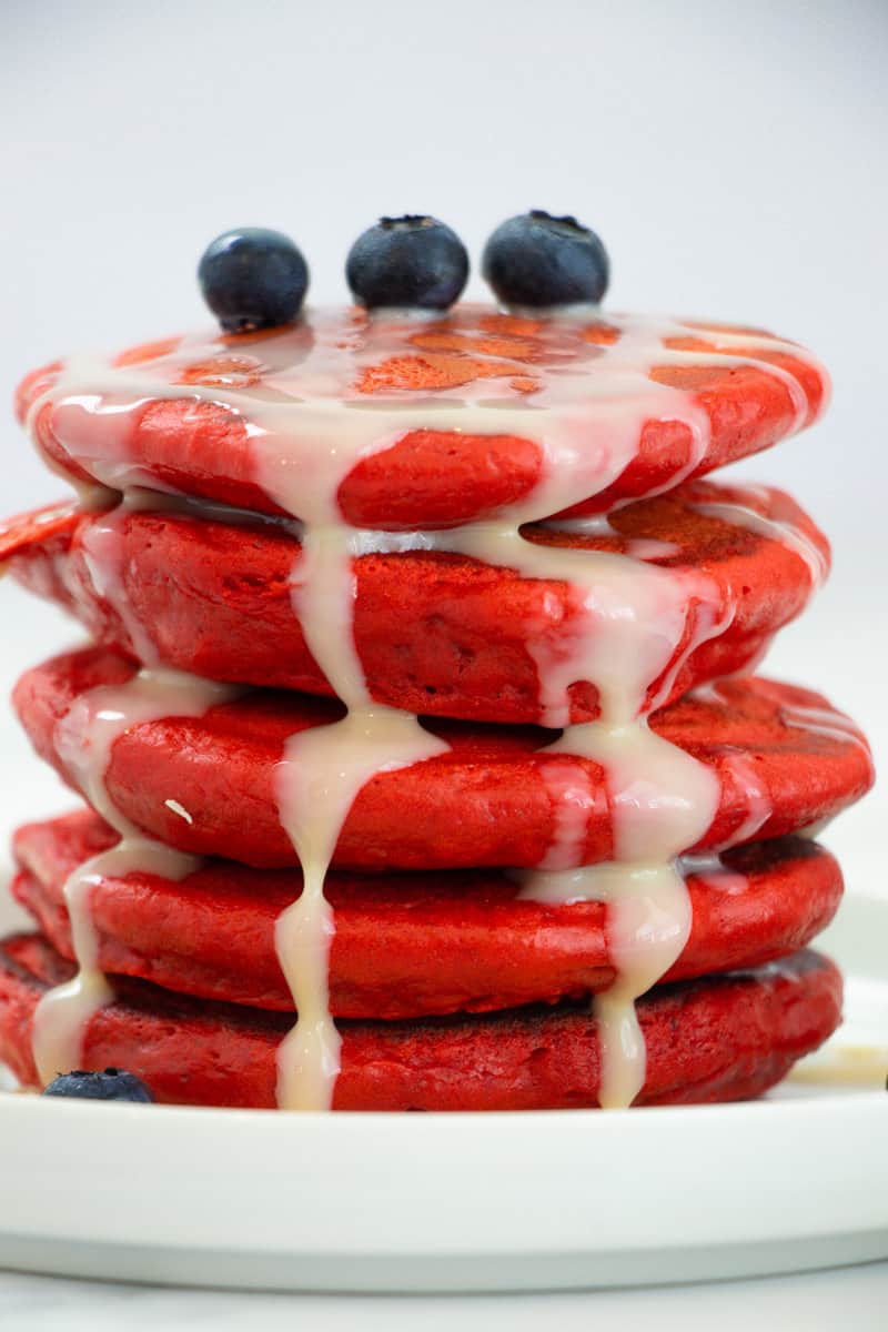 Stack of red velvet pancakes with condensed milk