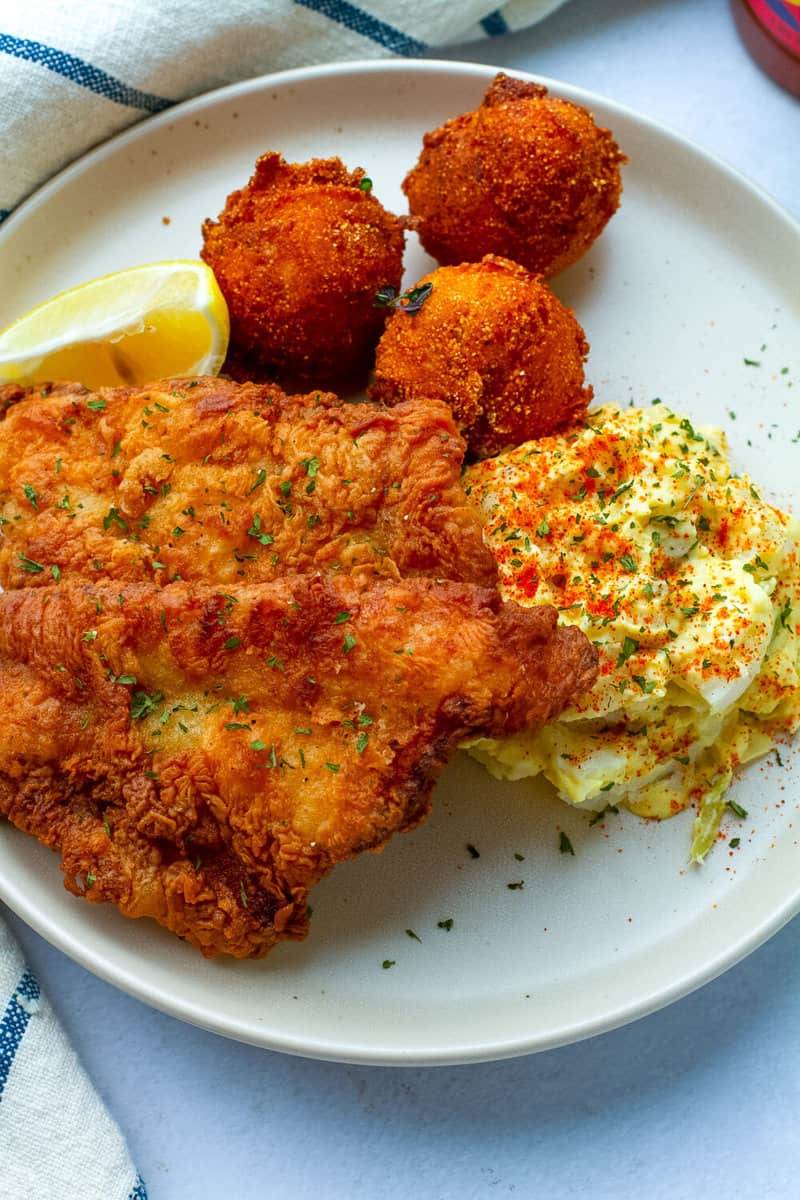 fried fish on a plate with potato salad