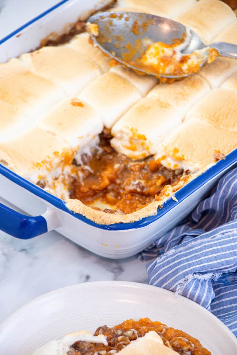 a scoop missing from vegan sweet potato casserole with marshmallows in baking dish