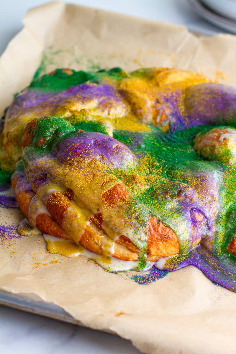 Whole king cake with Cream cheese filling on a baking sheet with knife