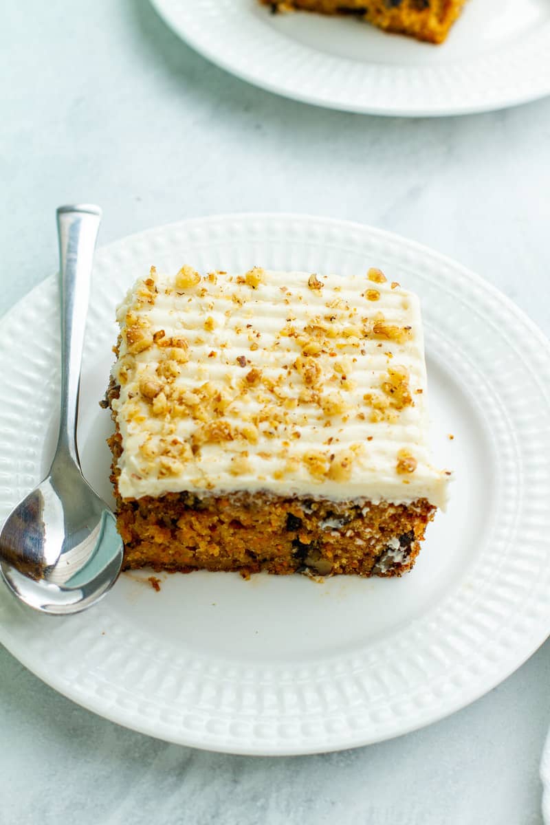 Carrot walnut cake on a plate with a spoon