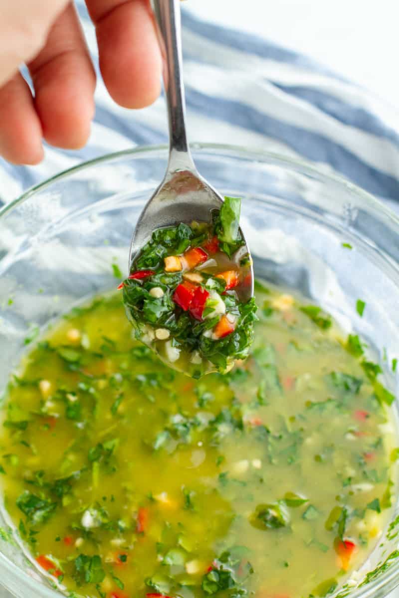 Chimichurri sauce on a spoon over a bowl