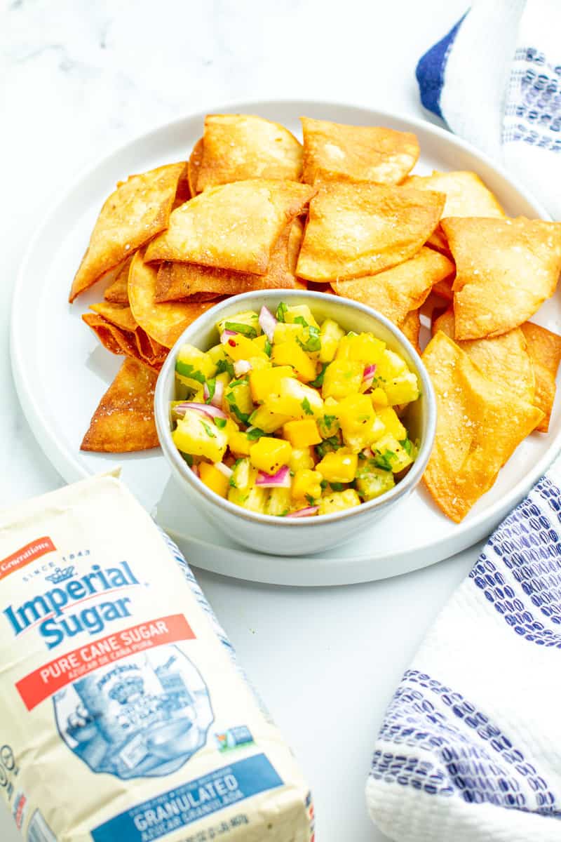Pineapple Mango Salsa in a bowl on a plate with tortillas chips
