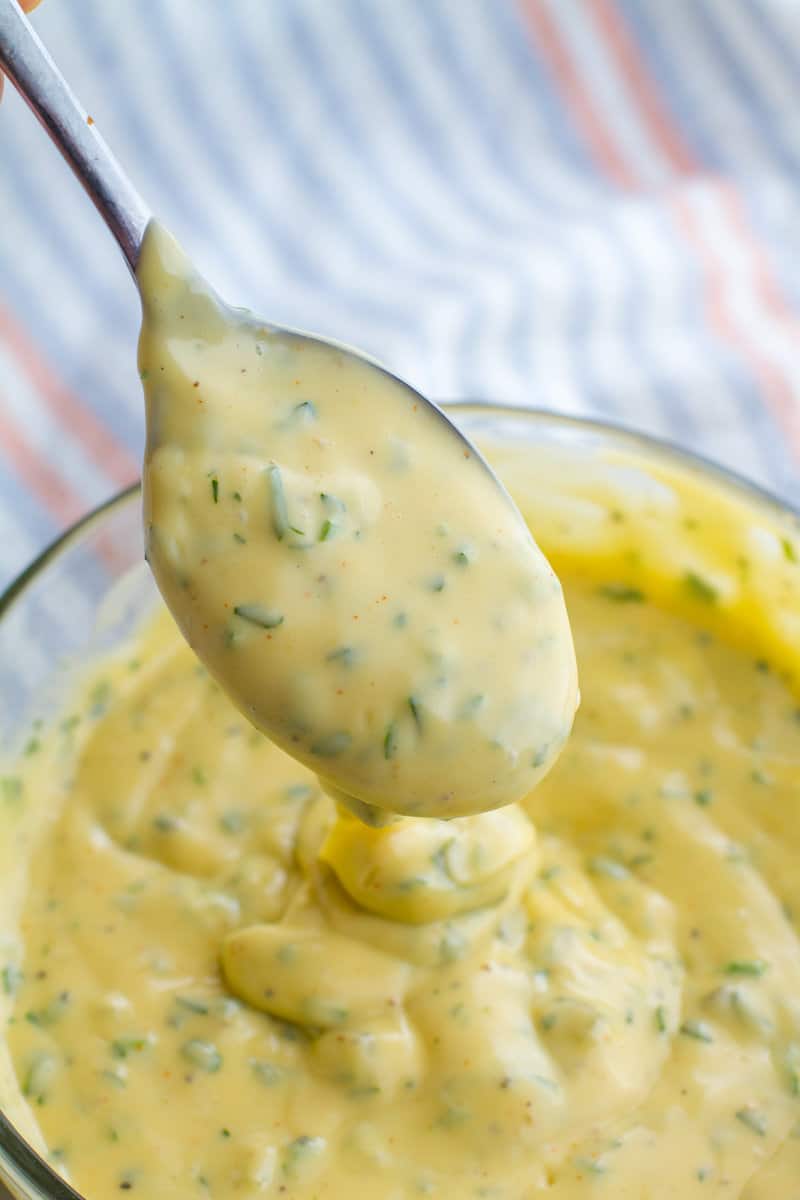 Pouring Homemade Tartar Sauce from a spoon over a bowl