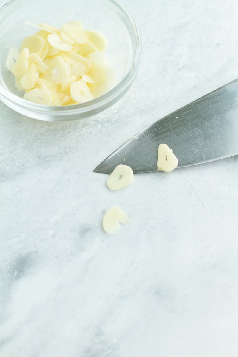 Thin sliced garlic on a knife