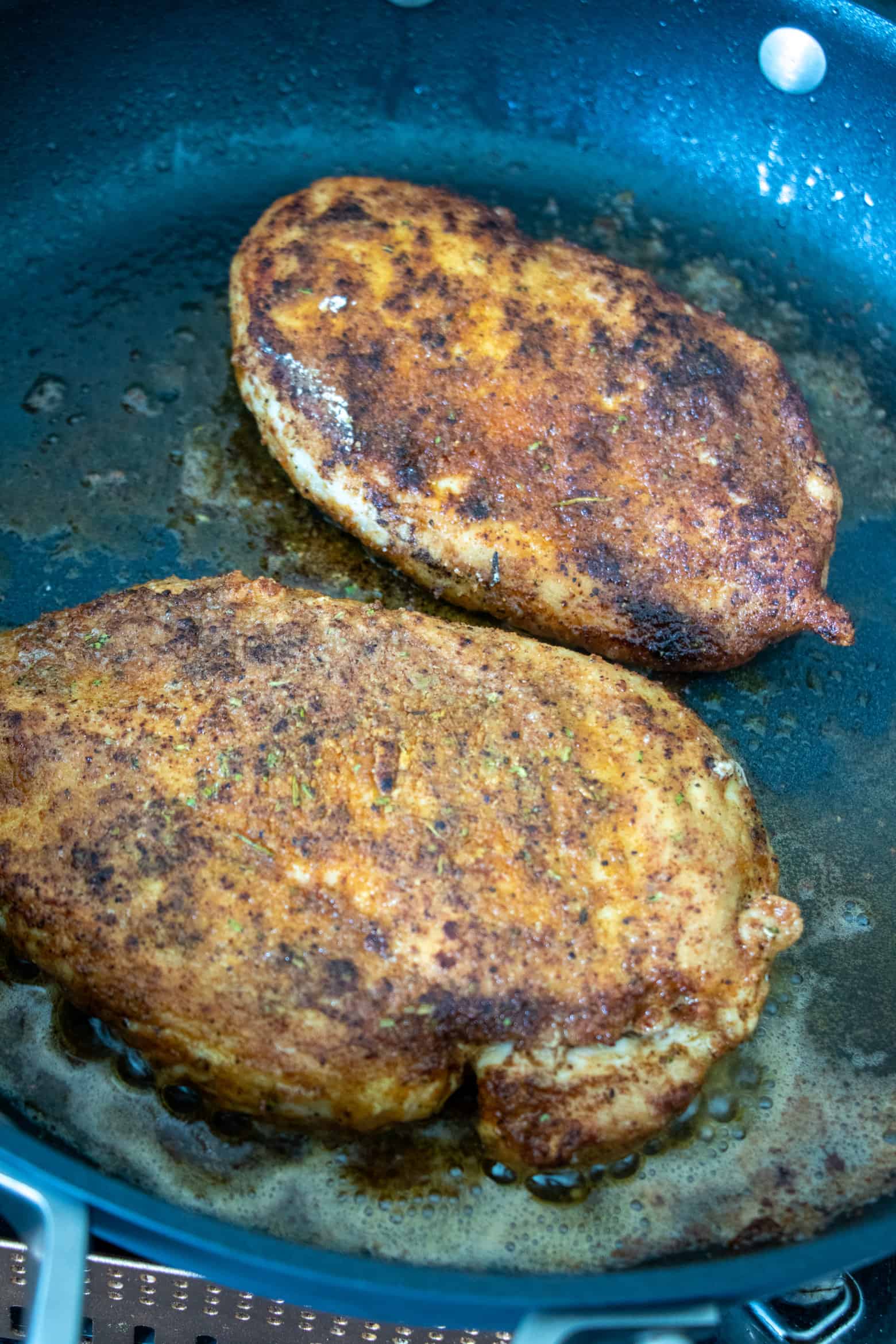 Chicken breast cooking in skillet