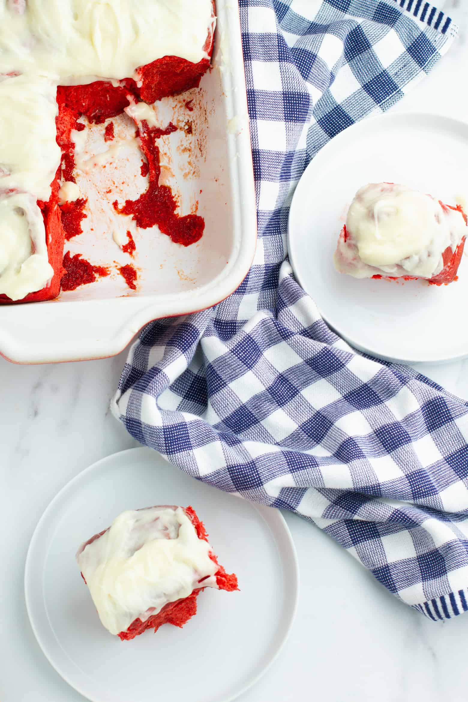 Red Velvet Cinnamon Rolls on a plate with the pan of cinnamon rolls.