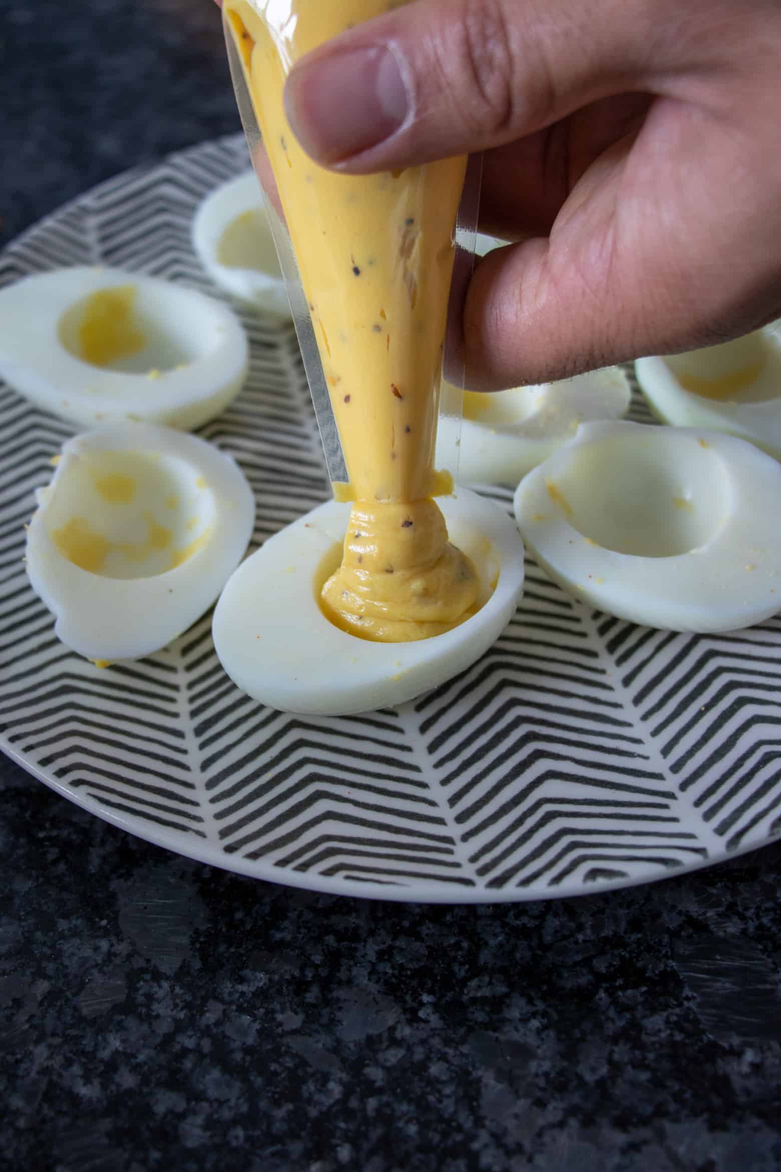 Southern Deviled Eggs being filled using a piping bag.