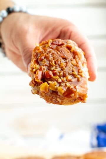 Sticky bun being held in hand.