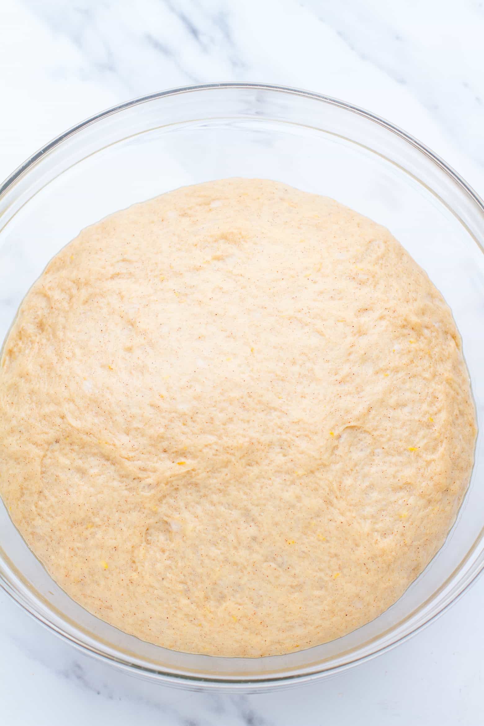 Sticky Bun dough in a glass bowl.