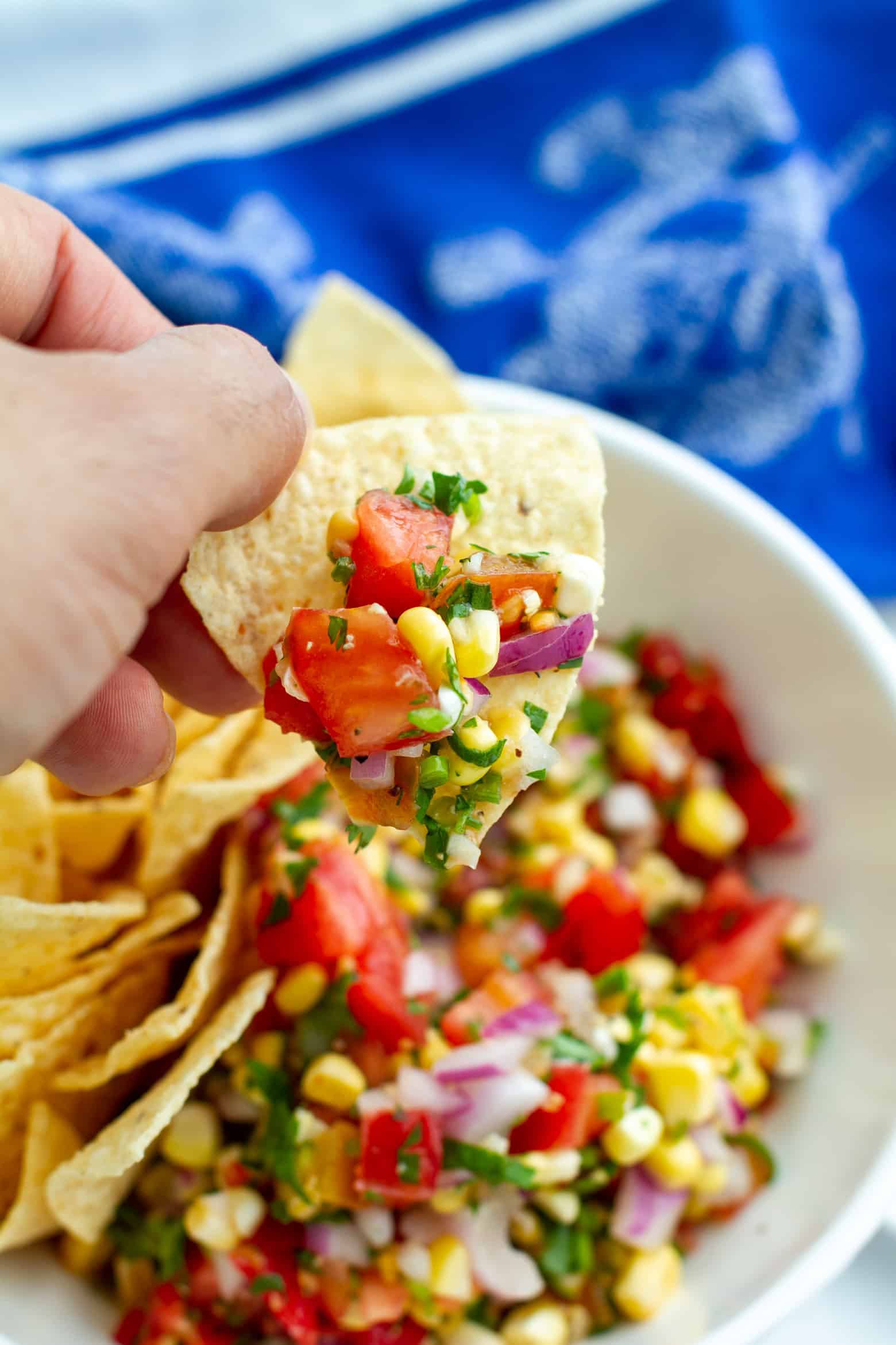 Tomato Corn Salsa on a chip being held.