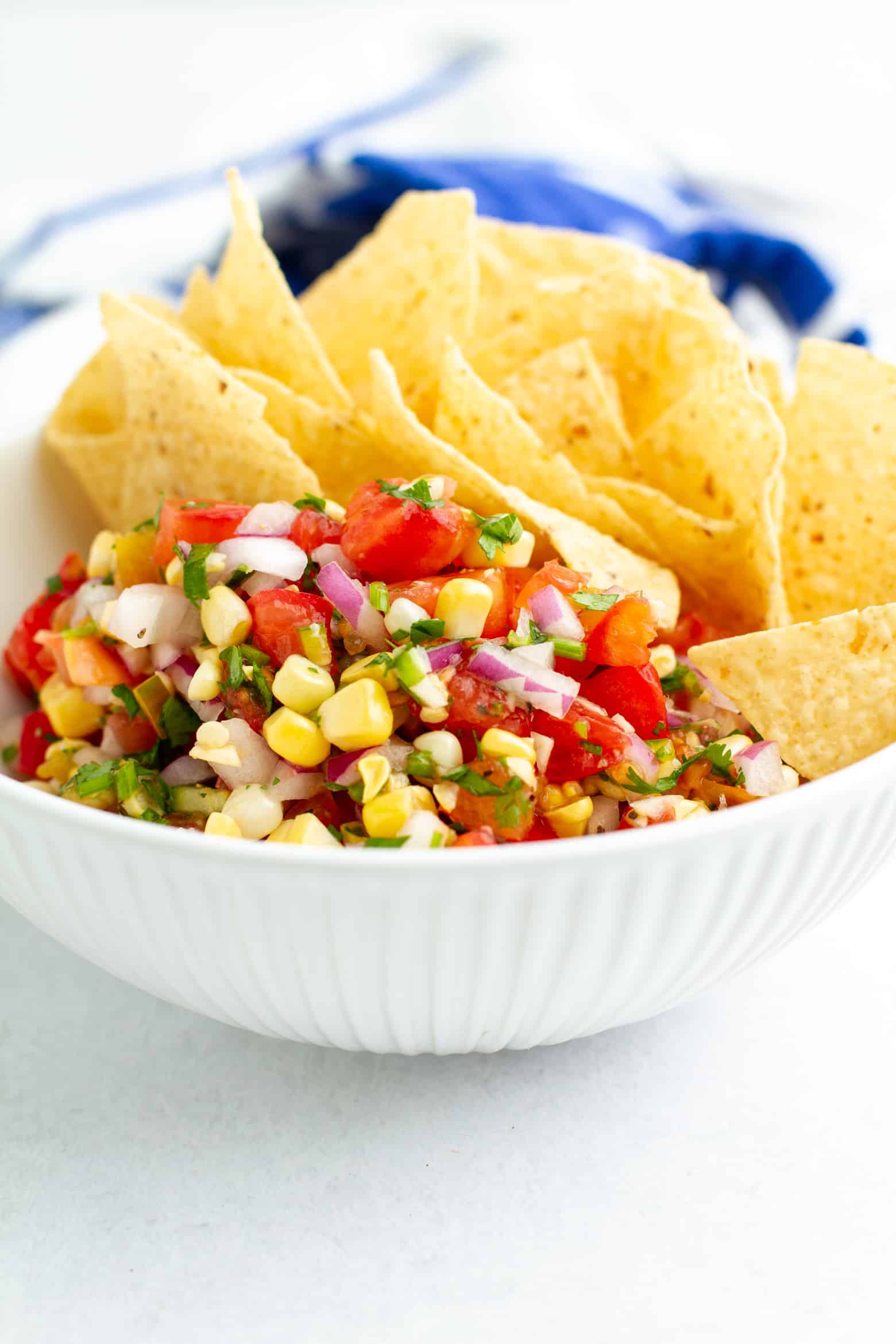 Tomato Corn Salsa in a bowl with tortilla chips.