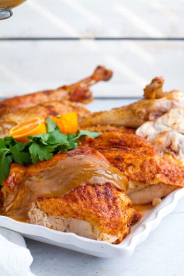 Turkey gravy being poured on roasted turkey.