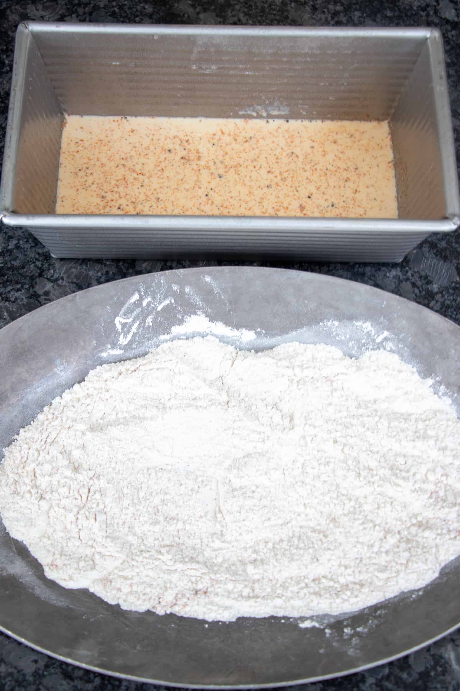 Seasoned milk and flour in different containers.
