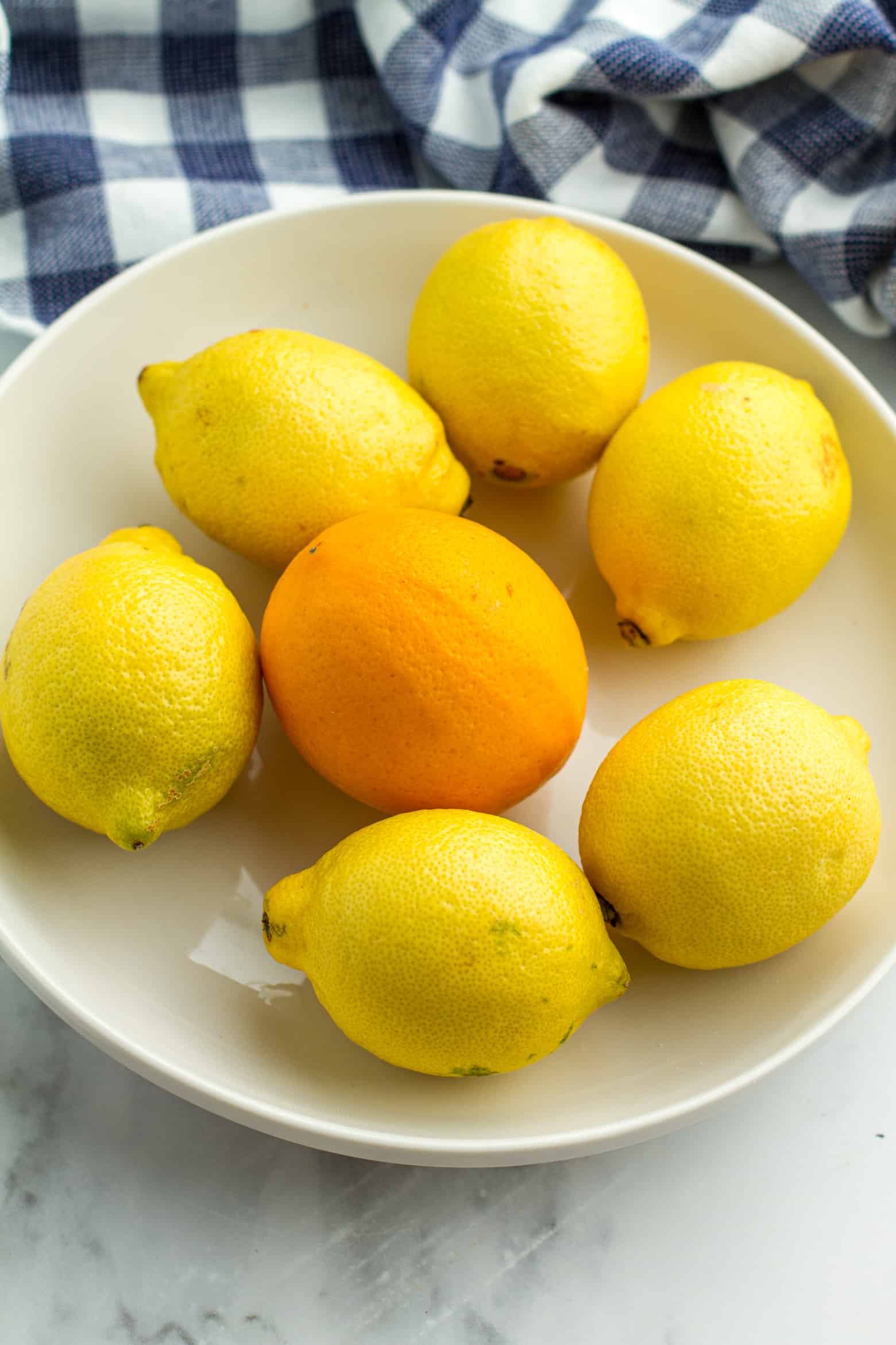 A meyer lemon and regular lemons in a bowl.
