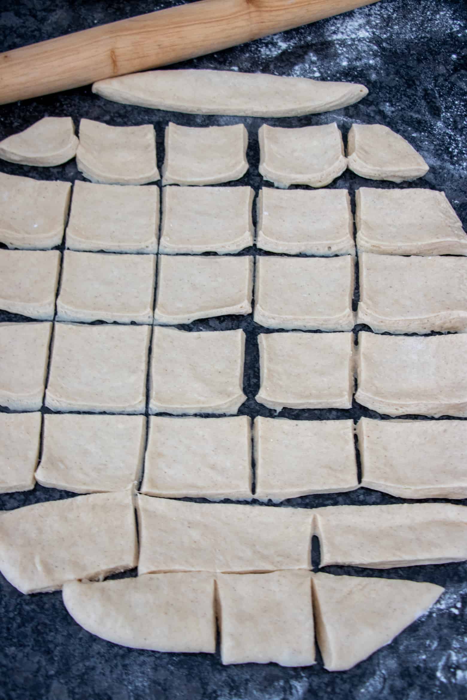 Rolled out beignet dough cut into squares.