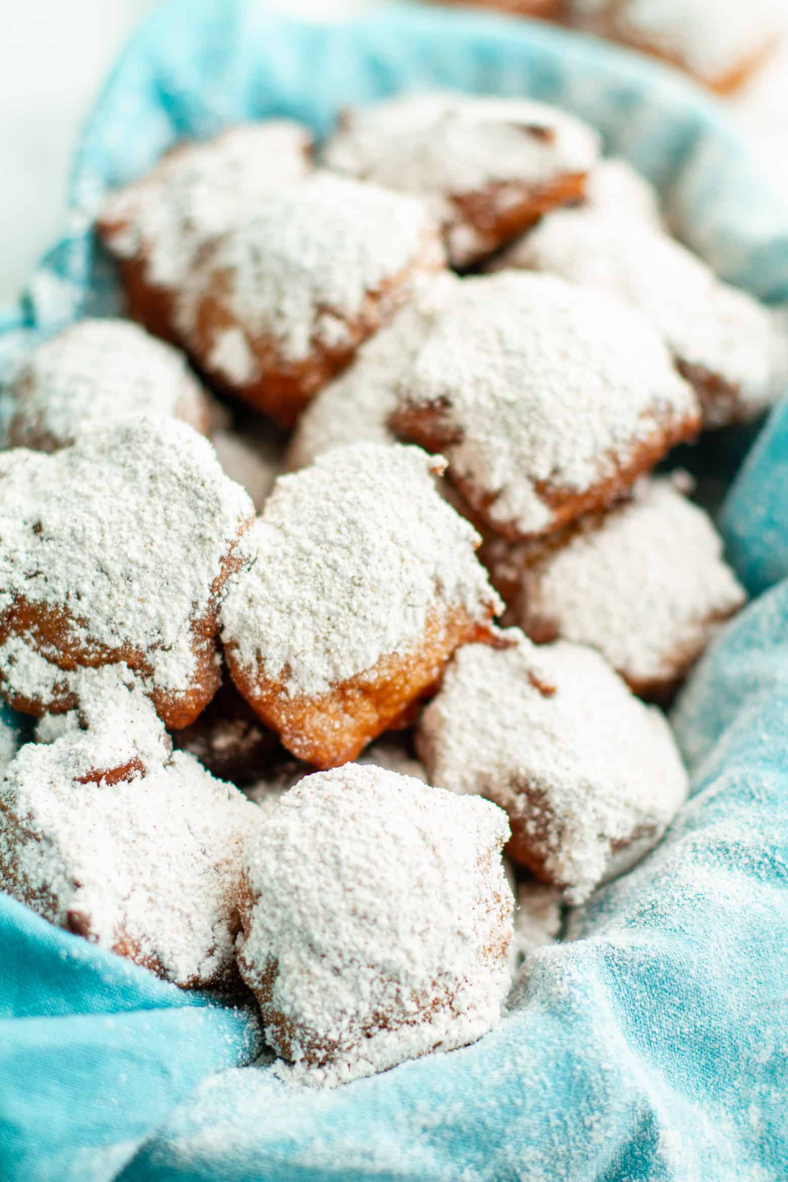 Calas dusted with powdered sugar on a platter. 