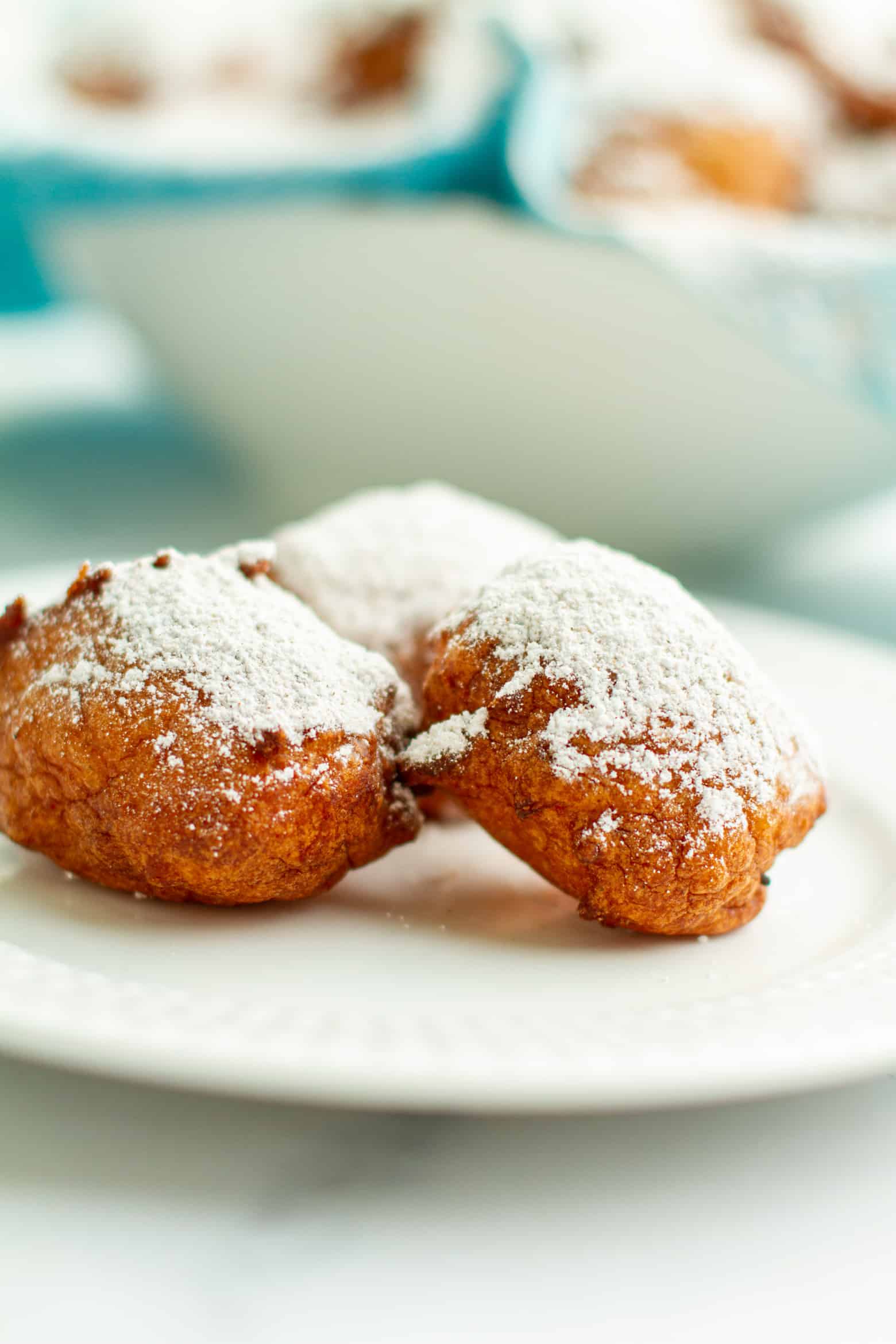 New Orleans Calas dusted with powdered sugar on a plate.
