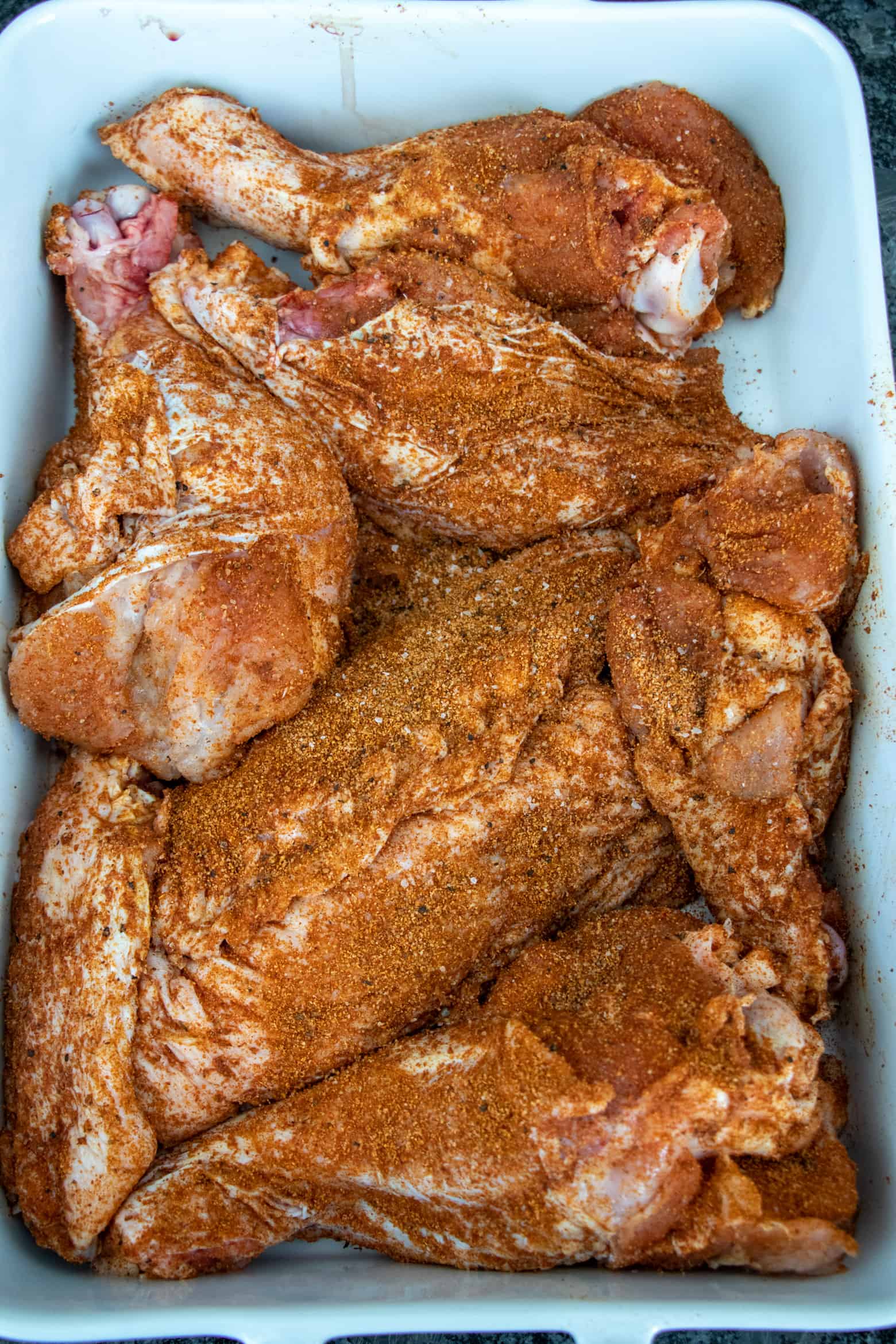 Seasoned turkey wings in a baking pan.