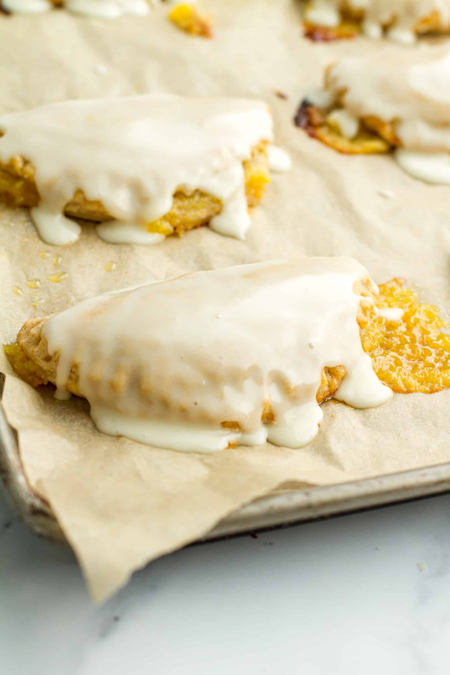 Iced lemon hand pie on a baking sheet.