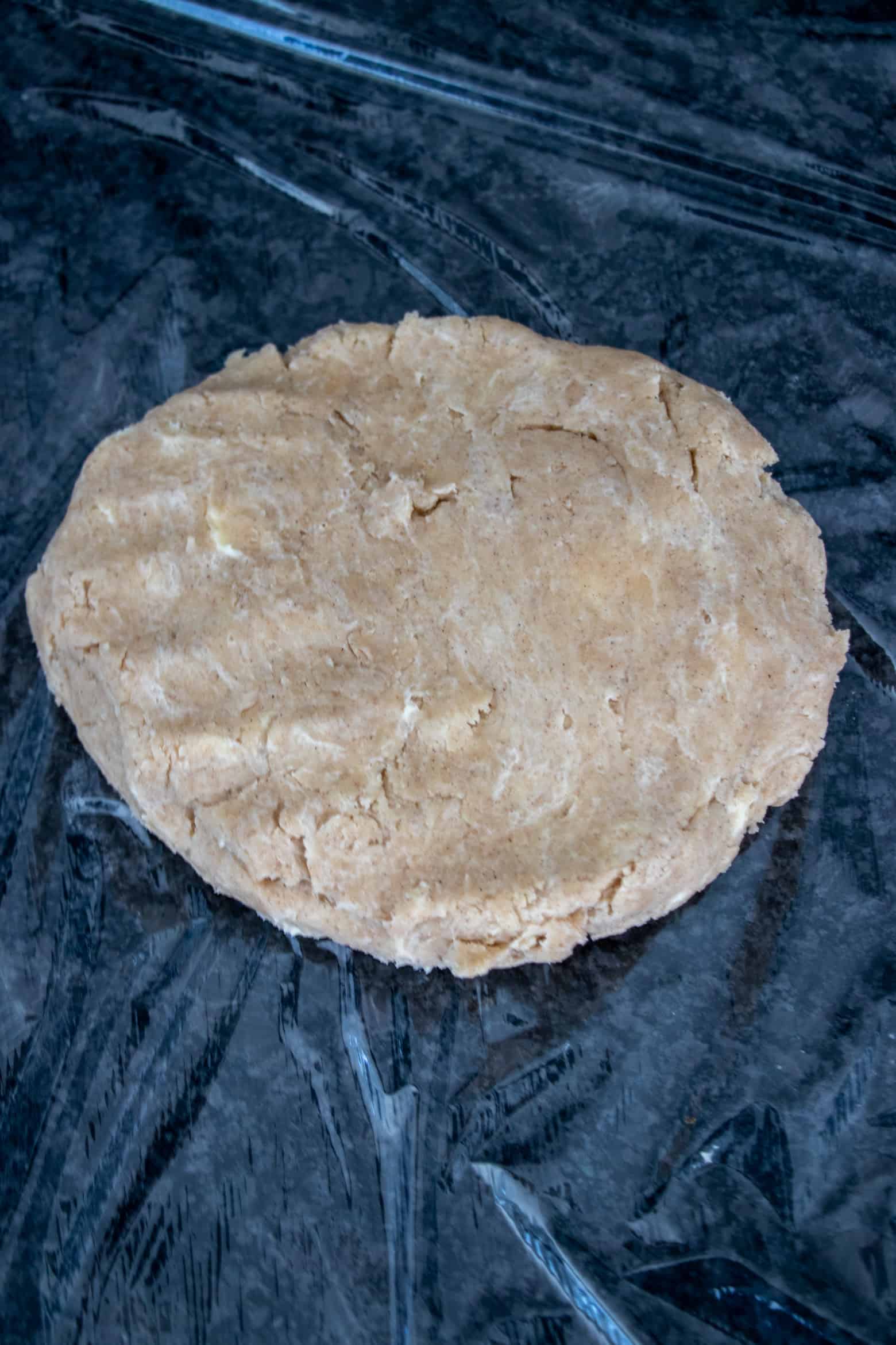 Pie dough shaped in a disc going to chill in the fridge.