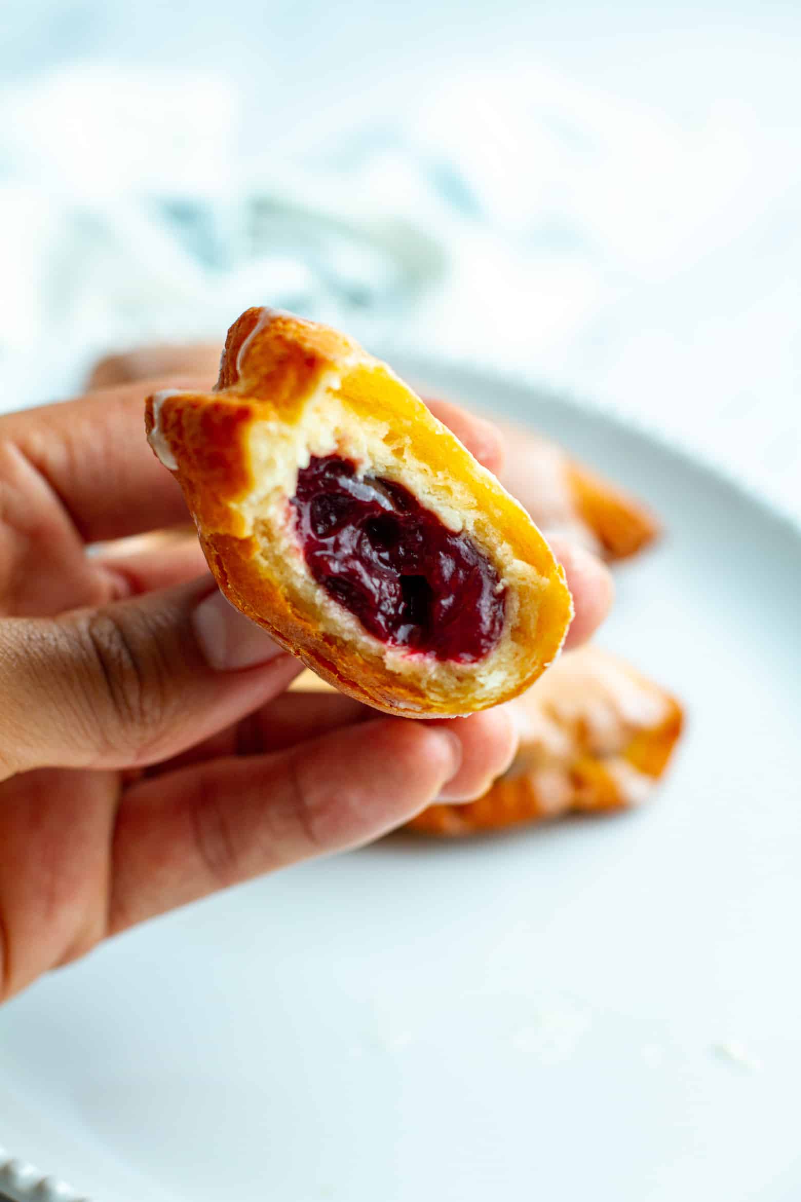 Cherry Fried Pie with a bite taken out being held in a hand.