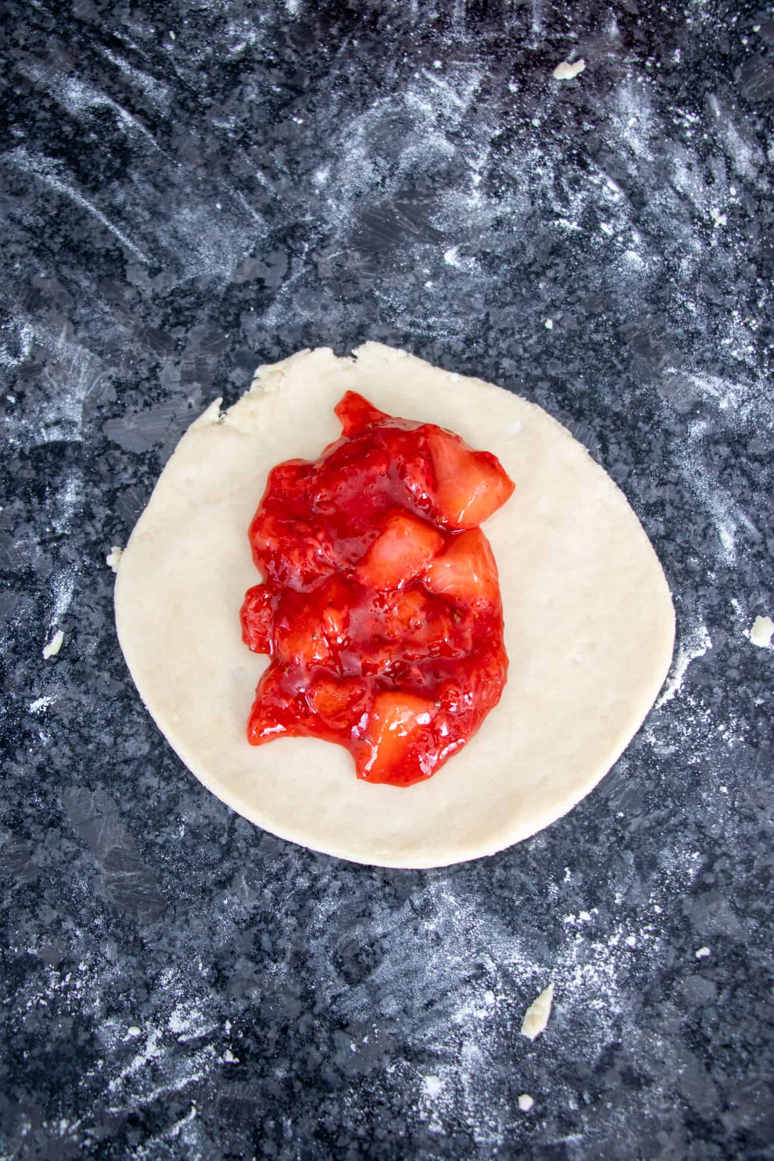 Strawberry pie filling in a pie dough circle.