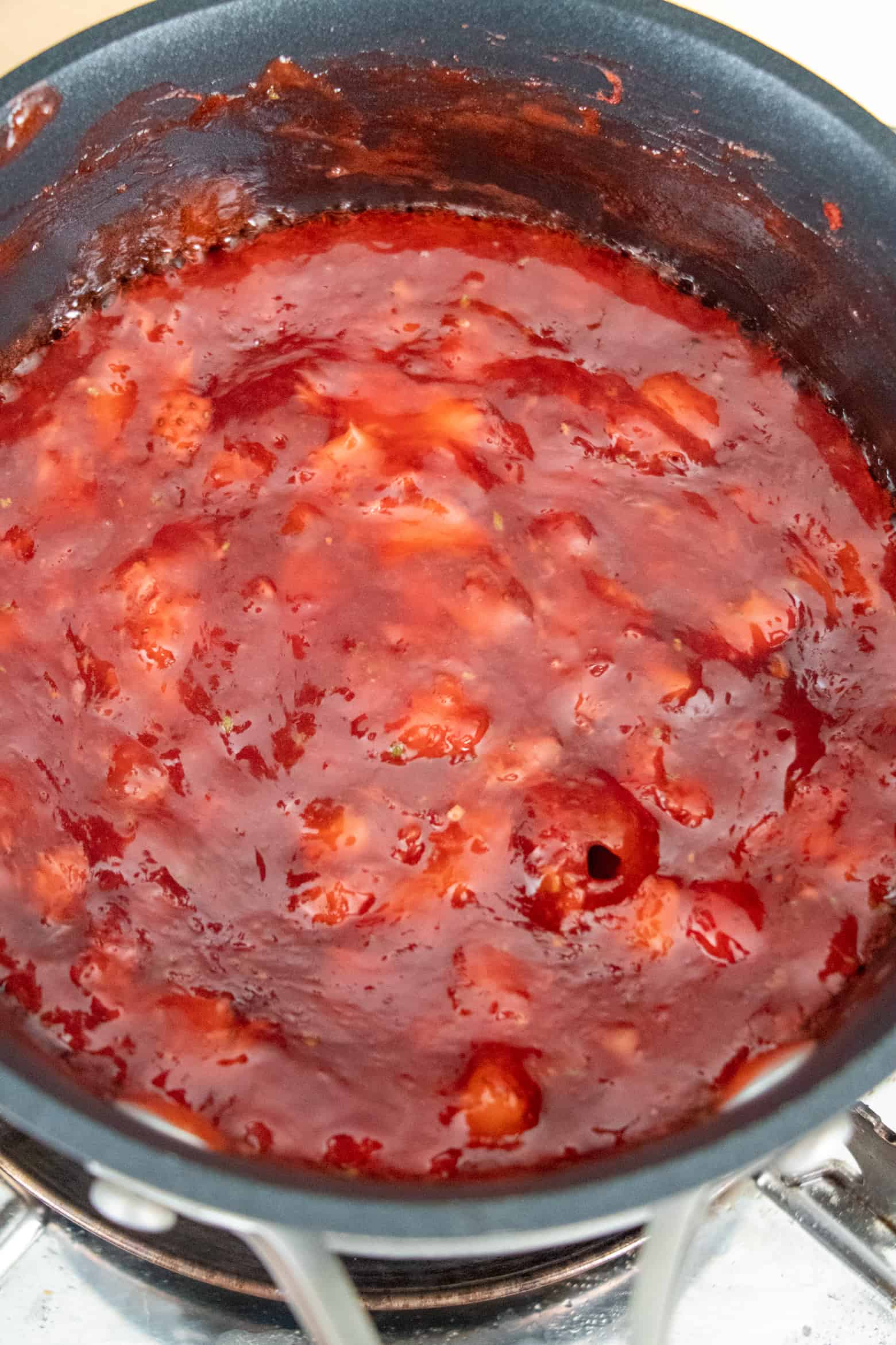 Strawberry pie filling boiling in a pot.