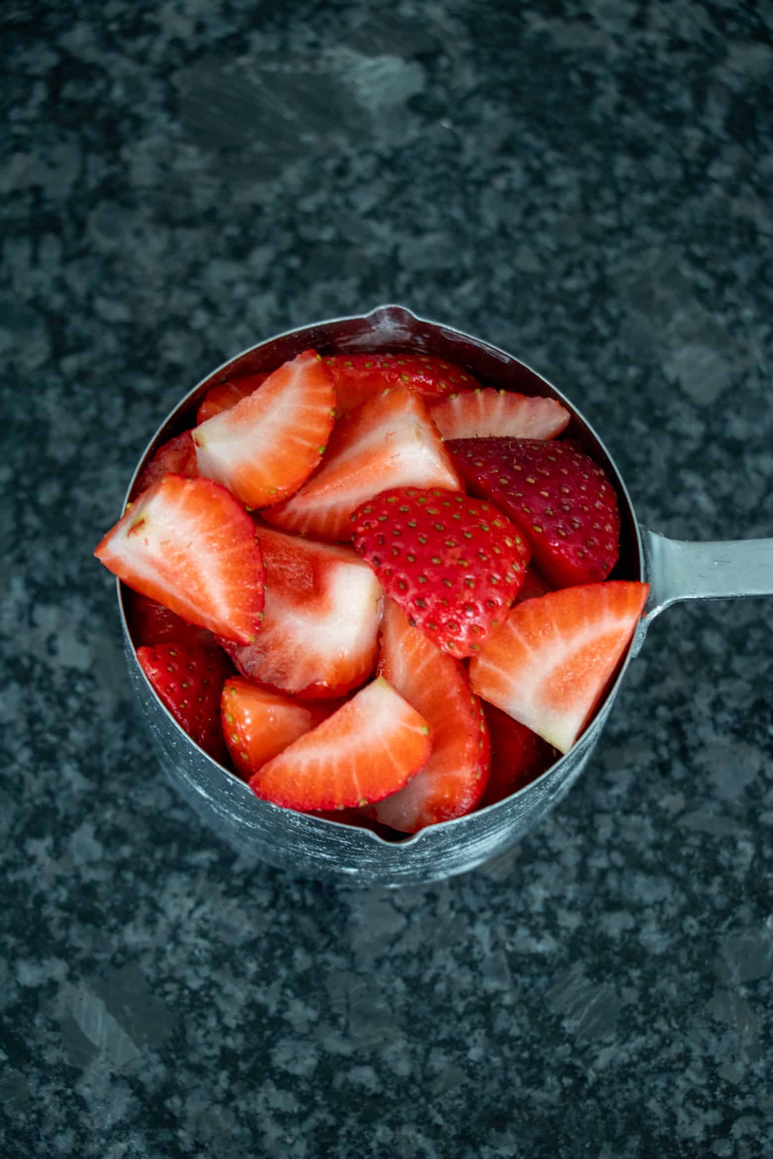 Strawberries packed in a measuring cup