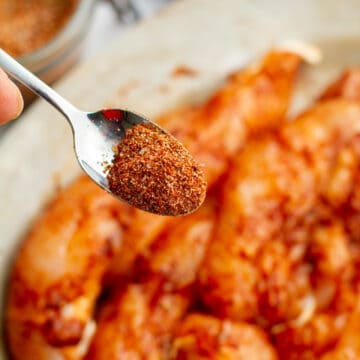 Chicken Taco Homemade Seasoning on a spoon over seasoned chicken.