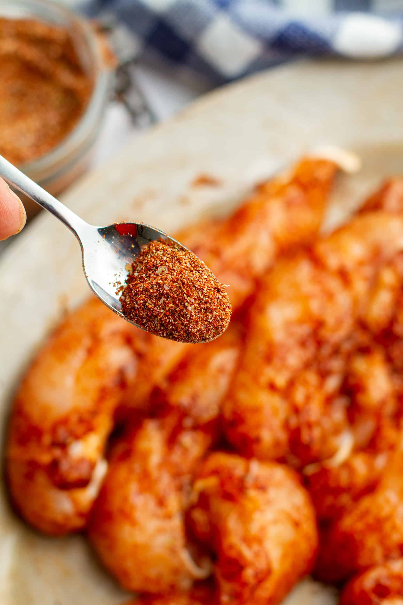 Chicken Taco Homemade Seasoning on a spoon over seasoned chicken.