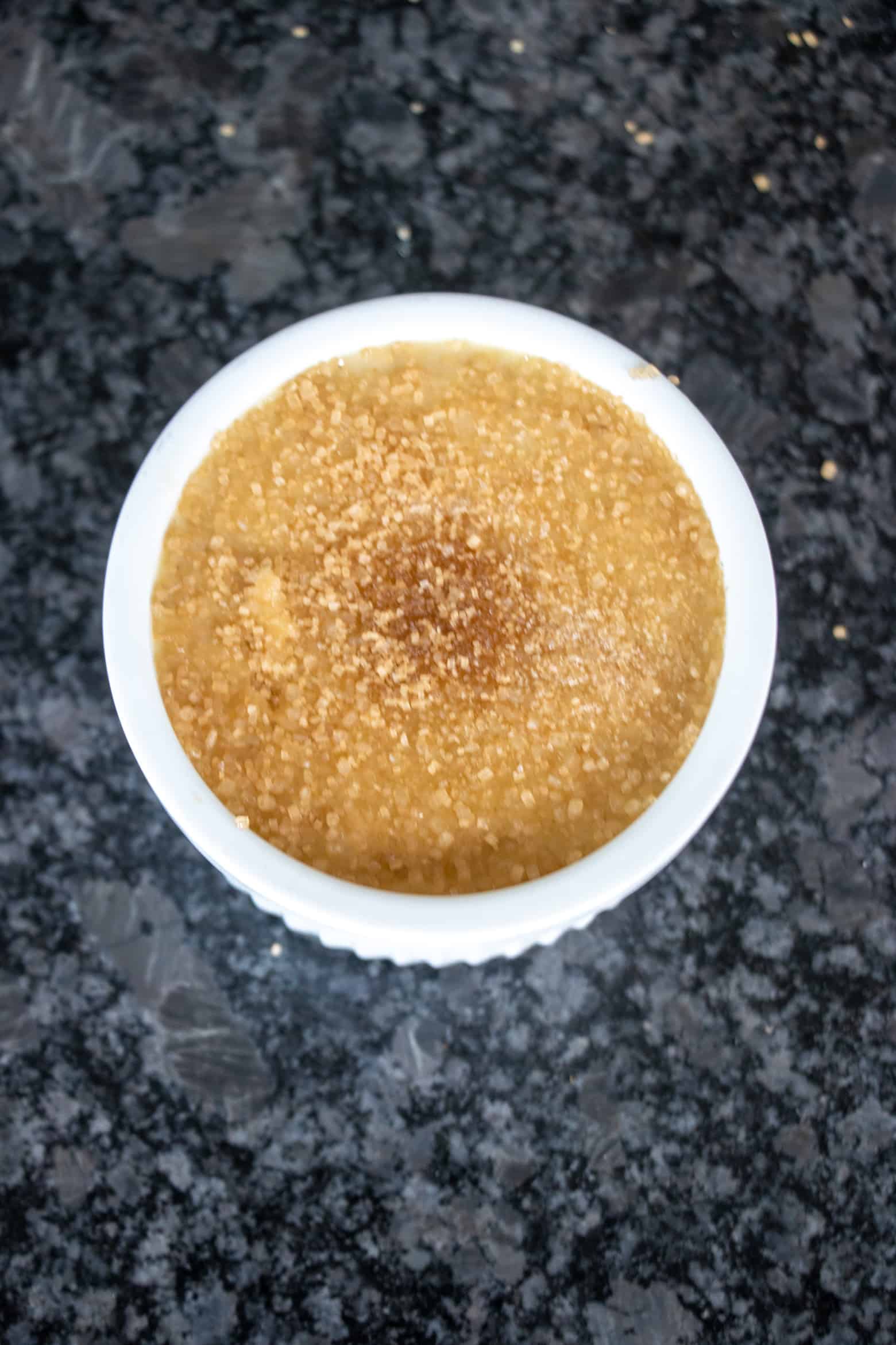 sugar on top of strawberry creme brulee before being torched.
