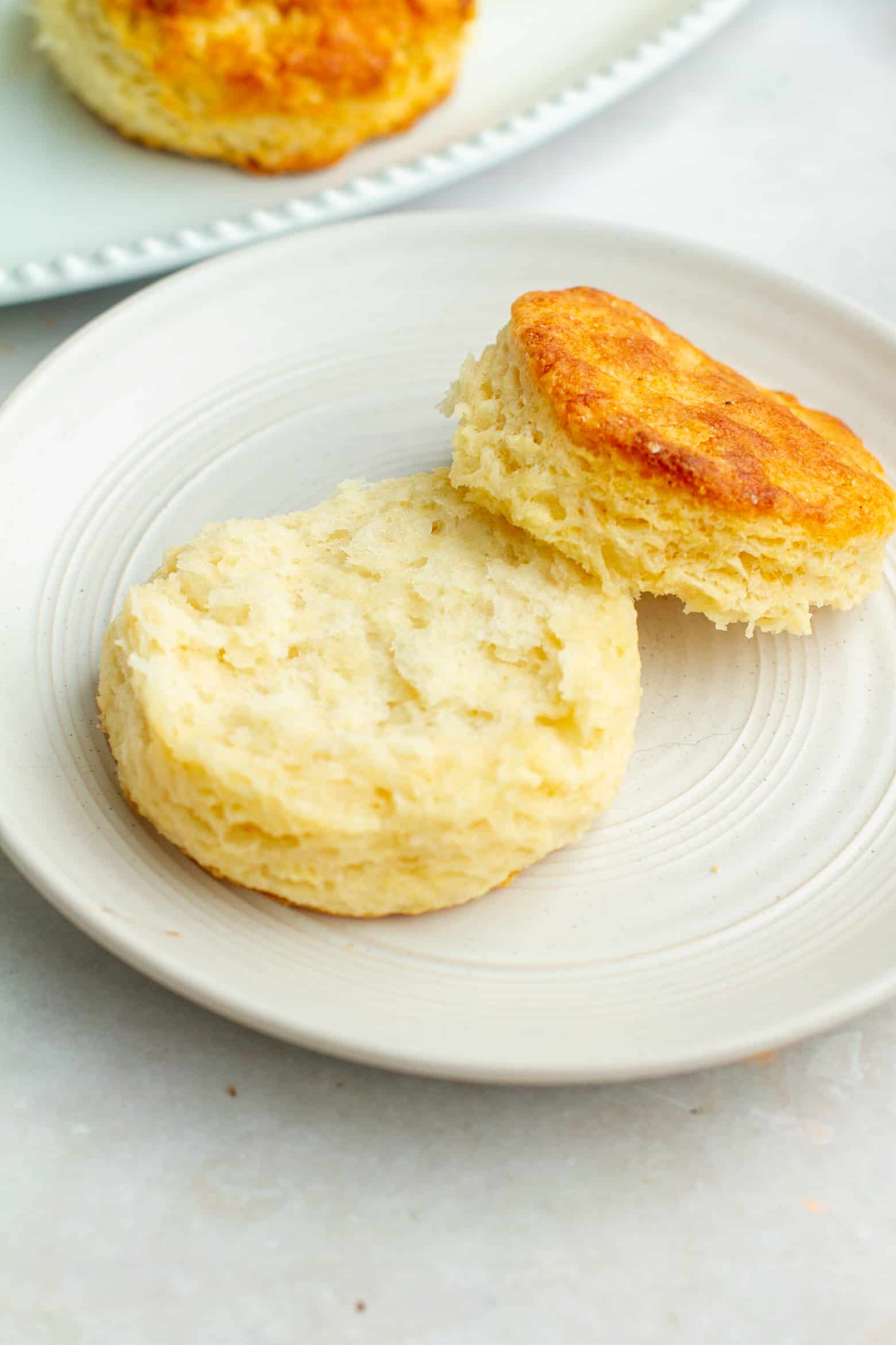 Halved flaky biscuit on a plate.