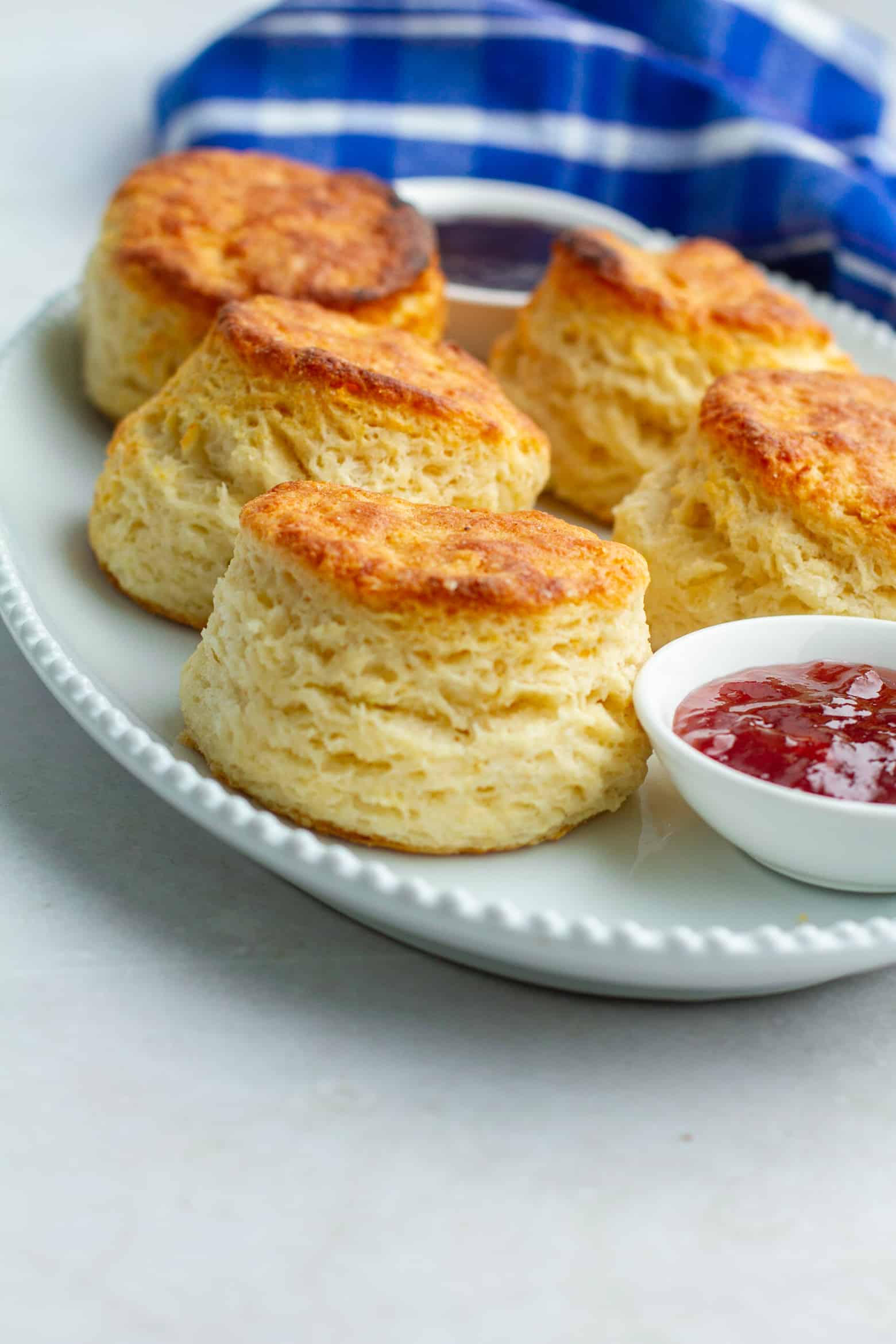Flaky biscuits on a platter with jam.
