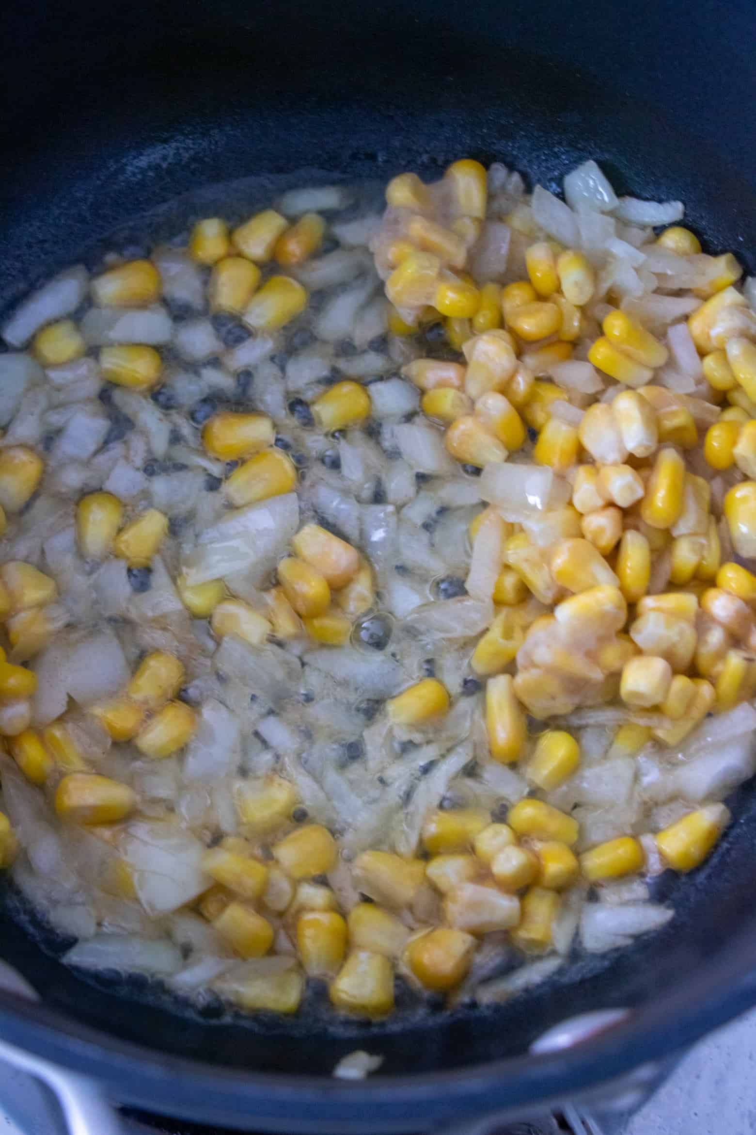 corn and onions cooking in a pot.