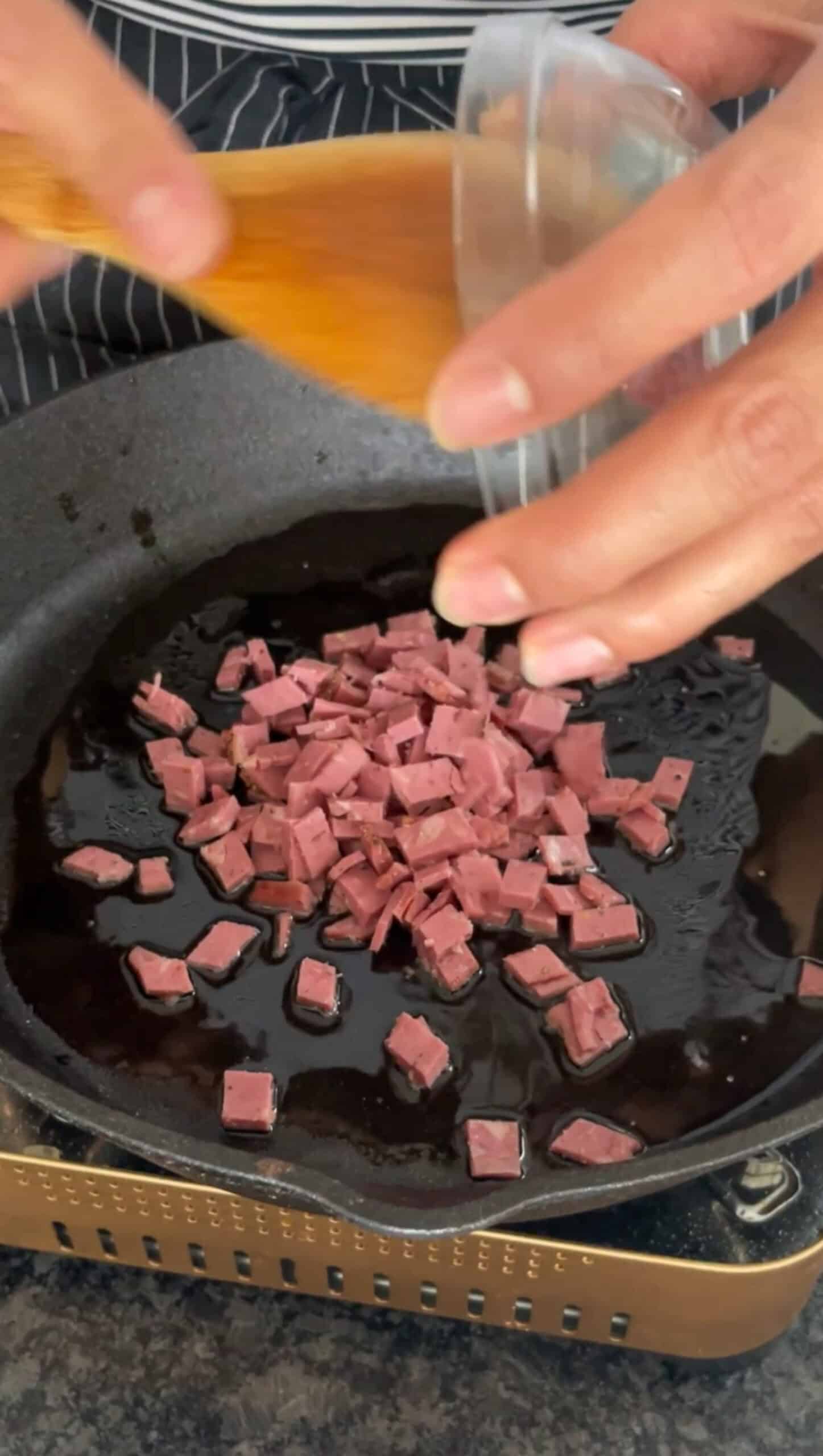 Bacon being cooked in skillet.